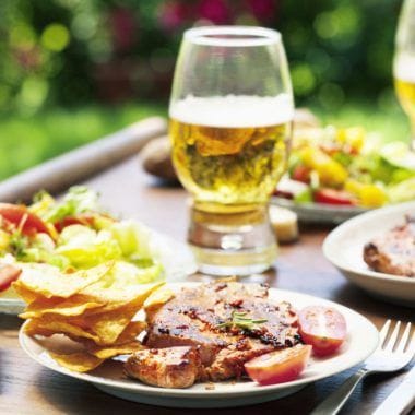 Barbecue with roasted pork. chips, salad and beer