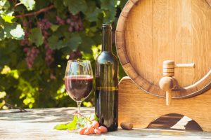 The wooden barrel with wine on a table outdoor. Winery culture