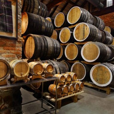 Rows of alcoholic drums in stock. Distillery. Cognac, whiskey, wine, brandy Alcohol in barrels. alcohol storage